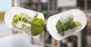 Blurred kitchen in the background, with capsule containing broccoli