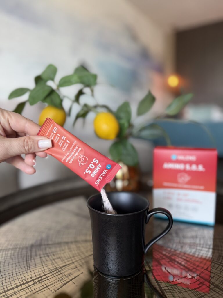 Amino Acids spplement in powder form. Sachet is being mixed into a glass of water.